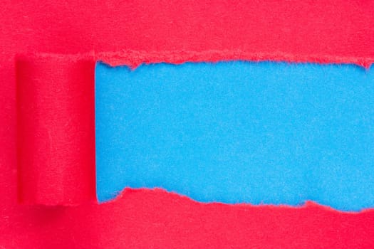 Red paper torn to reveal blue panel ideal for copy space.