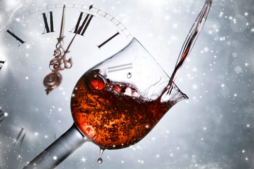 Red wine against fireworks, holiday lights and clock close to midnight