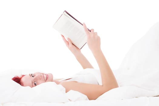 Happy woman in bed with a book while reading