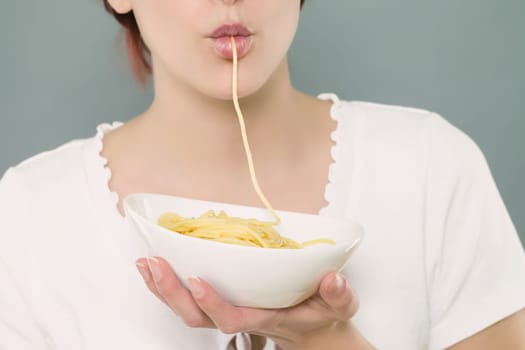 Close-up of a woman's mouth sucking spaghetti