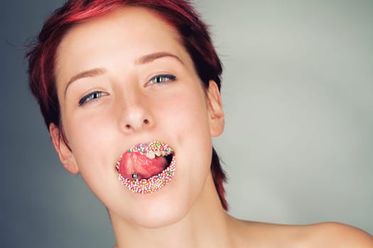 Beautiful woman licks her colorful sugar lips with her tongue