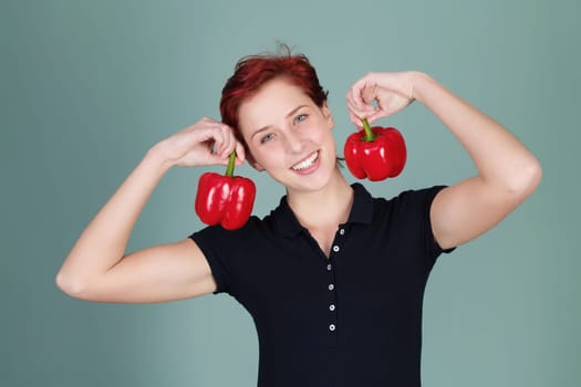 Young happy woman with two red peppers