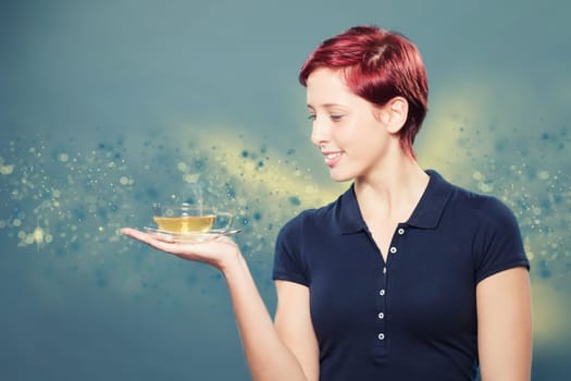 Beautiful red-haired woman holds a cup of yellow tea