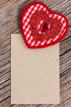 Red heart and  paper piece on a wood background