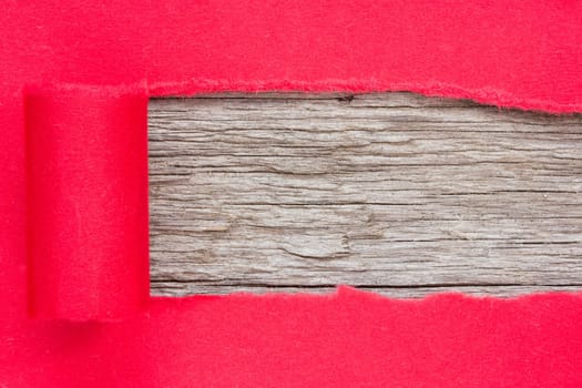 Red paper torn to reveal wooden panel for copy space.