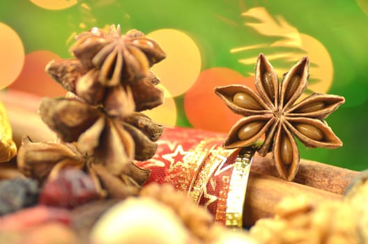 christmas spices, nuts and dried fruits on bokeh background