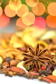 christmas spices, nuts and dried fruits on bokeh background