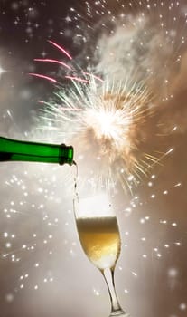 Pouring champagne against festive holiday lights