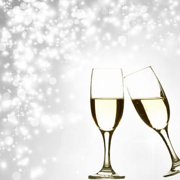 Glasses with champagne against holiday lights