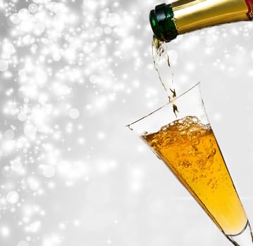 Pouring champagne against festive holiday lights