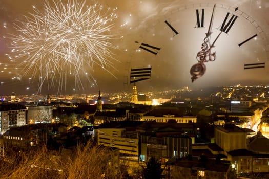 Holiday fireworks and clock close to midnight over the city