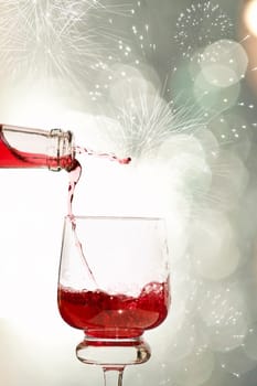 Pouring red wine against festive holiday lights