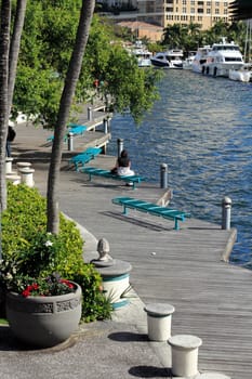 FORT LAUDERDALE, FLORIDA - FEBRUARY 3: Boats moored and people relaxing and walking along the wooden walkway at the Riverwalk beside the New River on February 3, 2013 in Ft Lauderdale, Florida.