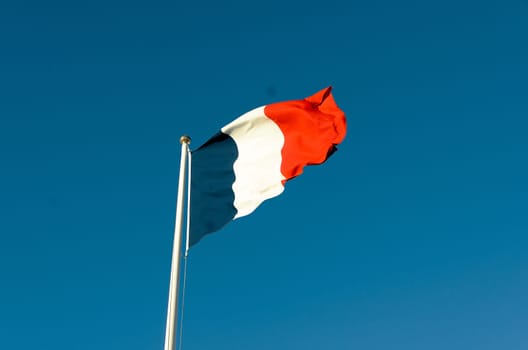 French flag on a sunny autumn day against a blue sky