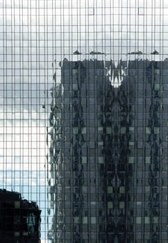 The abstract reflection of a high-rise façade in another high-rise building.