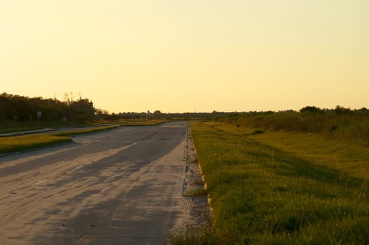Looking down a stretch of deserted empty road in rural Florida, Bonita Springs, at sunset.