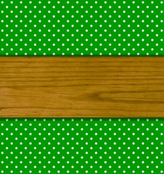 Green background with white dots and wooden board