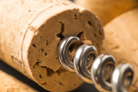 A corkscrew spiked in a wine stopper open.