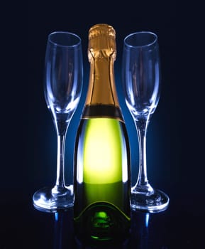 A bottle of champagne with 2 glasses on the side.