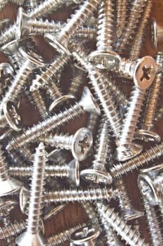 close up steel screws on wooden background