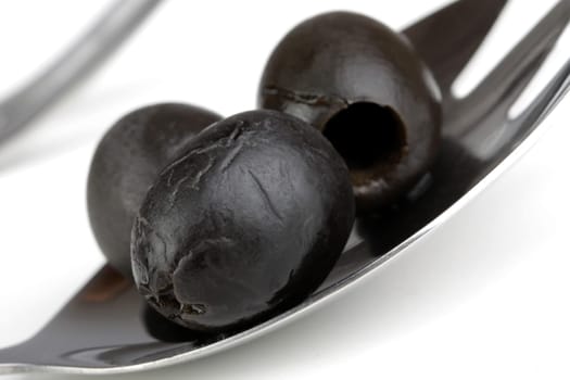 black olives on a metal spoon