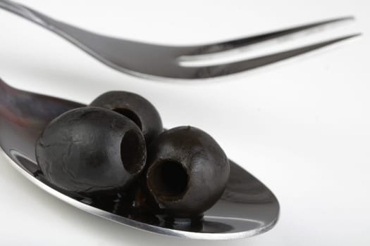 black olives on a metal spoon