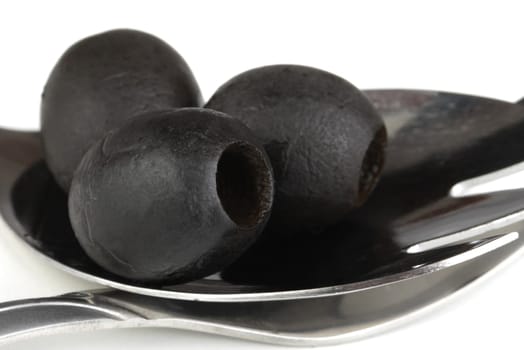 black olives on a metal spoon