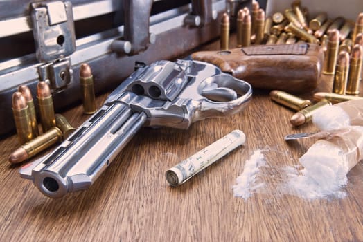 Image concept of drug trafficking. Gun, U.S. dollars, bullets and cocaine on the table.
