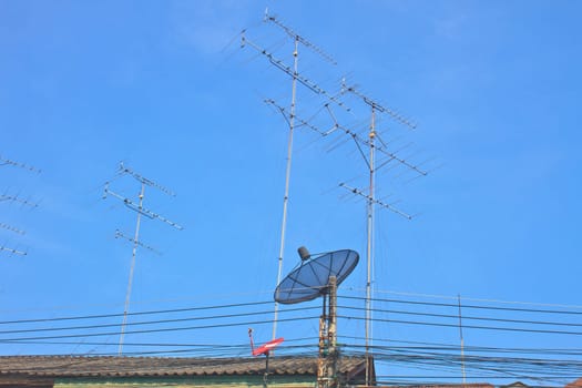satellite dish and Television antenna on roof with blue sky