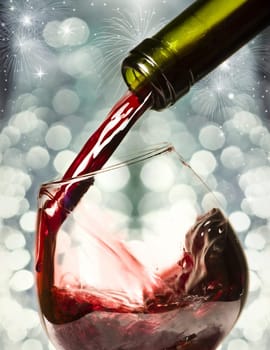 Red wine against fireworks and holiday lights