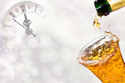 Pouring champagne against holiday lights and clock close to midnight.