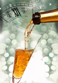 Pouring champagne against holiday lights and clock close to midnight.
