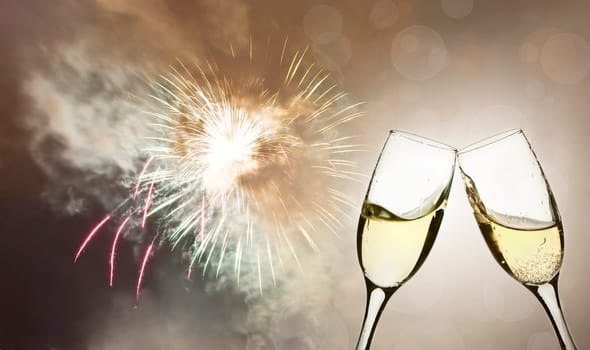 Glasses with champagne against fireworks and holiday lights
