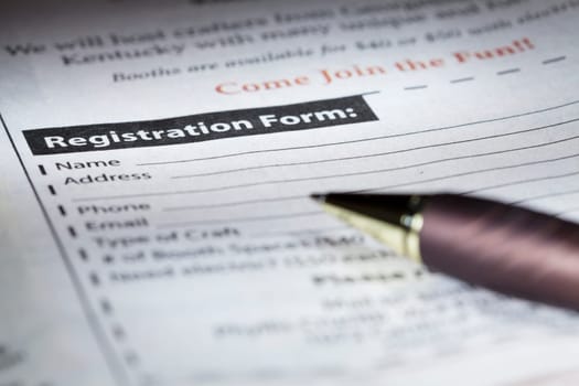 Closeup image of a blank registration form and a pen