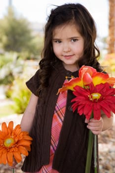 Outdoors portrait of a happy little girl with flowers
