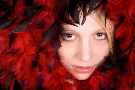 Face of a beautiful young woman surrounded by feathers