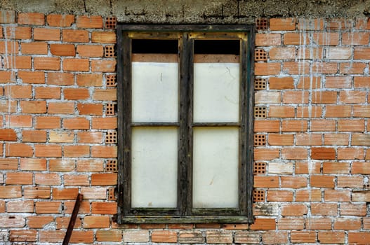 Stained brick wall and boarded up window. Abandoned house detail.