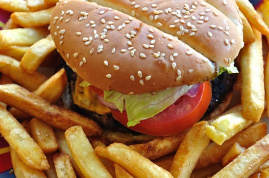 Cheeseburger and chips detail. Fast food background.