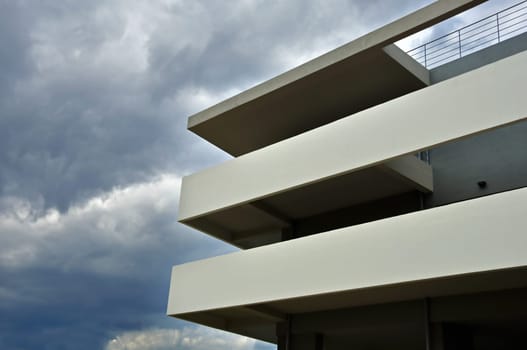 Stormy clouds and modern building facade and balcony. Architectural detail.