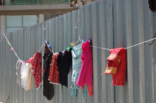 Laundry drying on metal fence. Urban street scene.