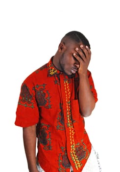 A young black man standing for white background with his hand on his.face, looking very sad..