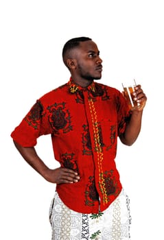 A handsome young black man standing for white background with a glass.of tee in his hand..