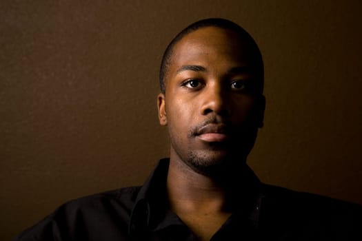 Portrait of a handsome young black man with dark background
