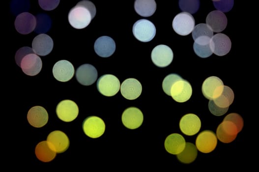 Blurry light circles colorful dots pattern at night. Abstract background.