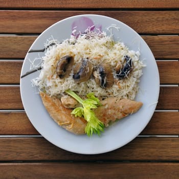 Chicken breast with rice, mushrooms and white cream sauce. Food background.