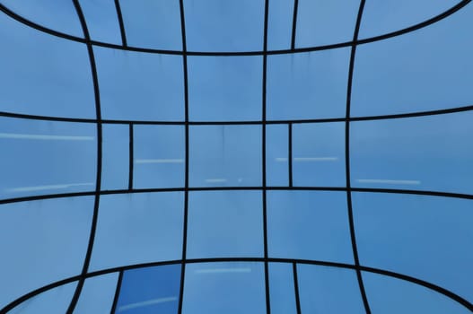 Distorted glass facade of modern building. Abstract architectural detail.