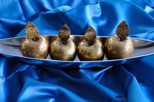 Golden apples on blue background. Christmas symbol vintage decorative objects.