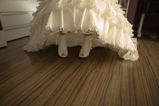 The bride shows their pit toe shoes rising her gown