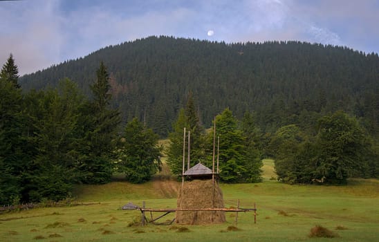 haystack against the mountain with the moon