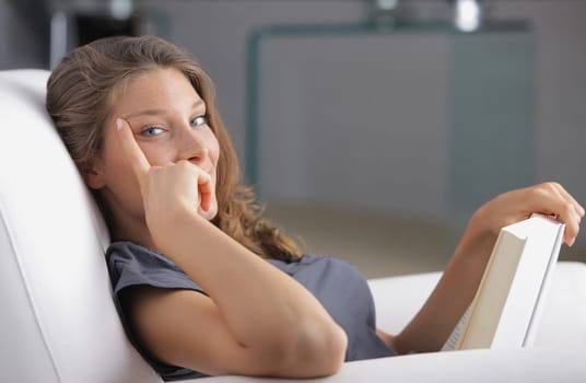Portrait of a young beautiful woman reading a book